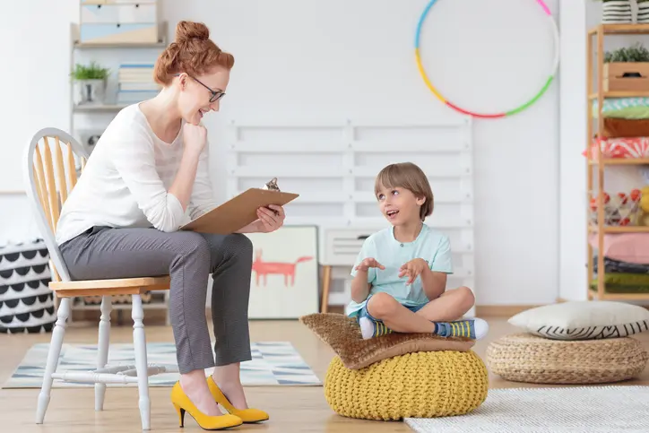 Woman and child talking in a playroom.